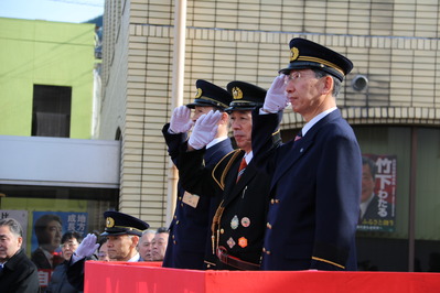 行進する隊員に向かって敬礼する楫野市長