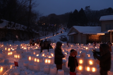 日が沈み幻想的な雪景色に灯がともるたくさんのキャンドル