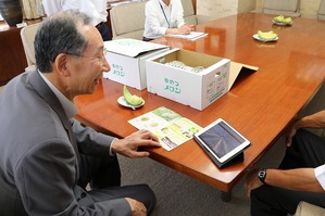 タブレットでメロンができる様子を見る市長