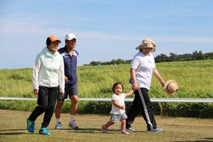 お母さんに手を引かれて歩く子ども