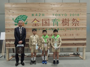 校長先生と育樹祭の木製看板の前で記念撮影