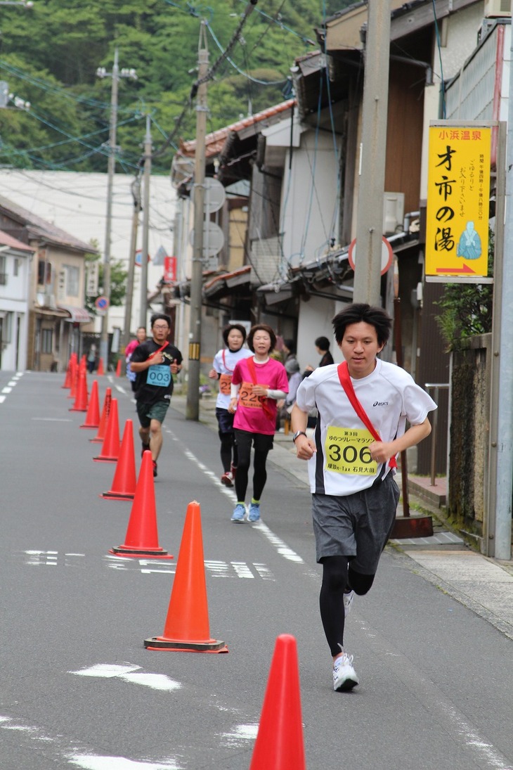 町の通りを走り抜く選手