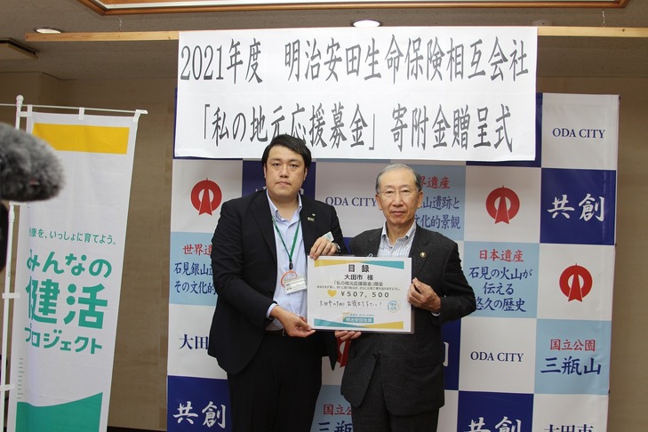 目録を手にする市長