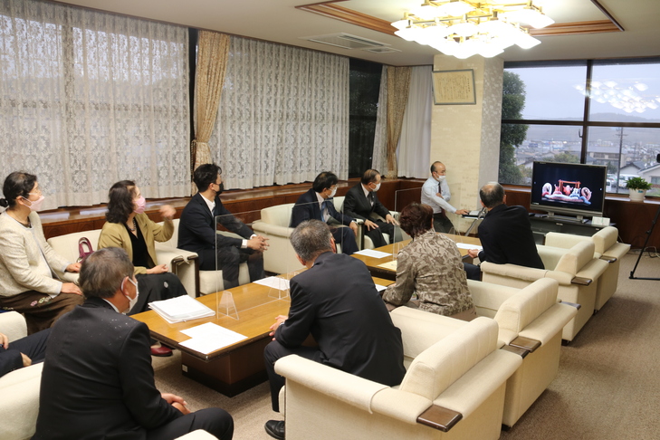 映像や写真を観る市長と実行委員会のみなさん