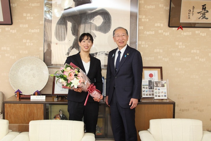 花束を手にして写真に納まる大野さんと市長