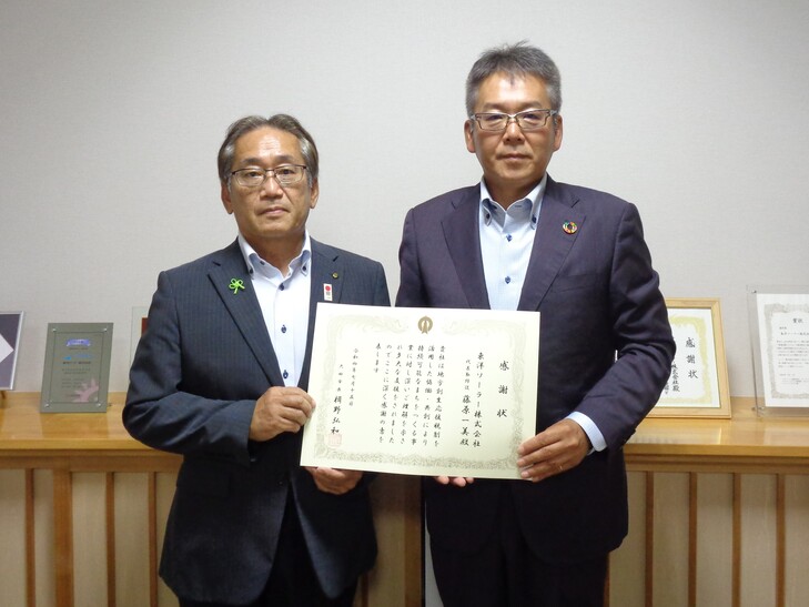 副市長と記念撮影をする藤原代表取締役