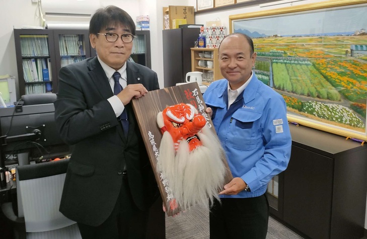 政策企画部長と記念撮影をする田中取締役管理本部長