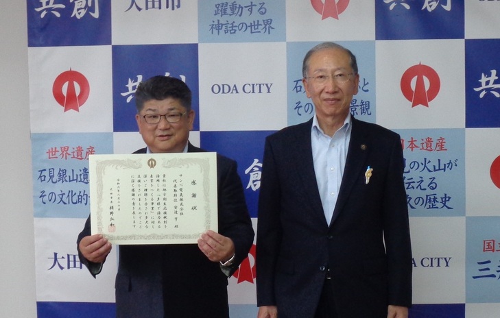 市長と記念撮影をする安達代表取締役