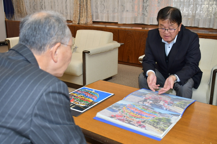 市長に写真を見せる須藤会長
