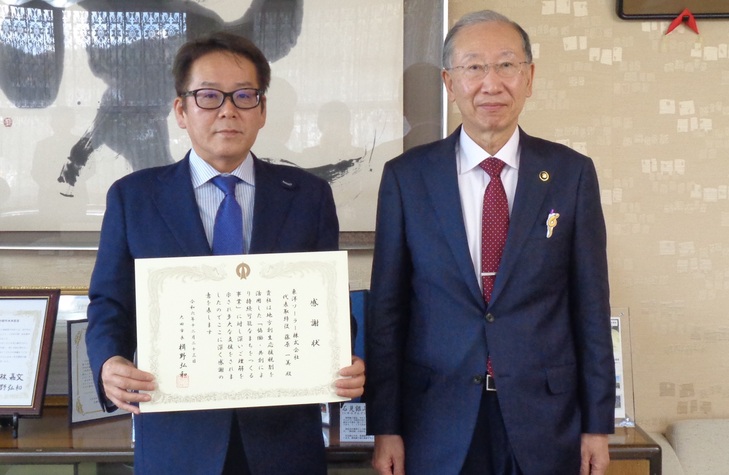 市長と記念撮影をする藤原代表取締役