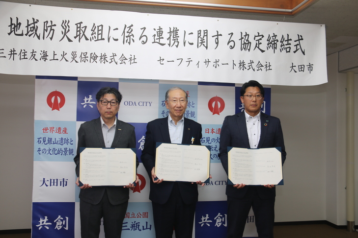 協定書を持った集合写真