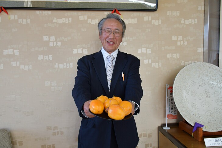 柿を持つ岡田代表理事