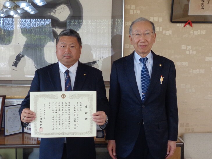 市長と記念撮影をする佐藤代表取締役