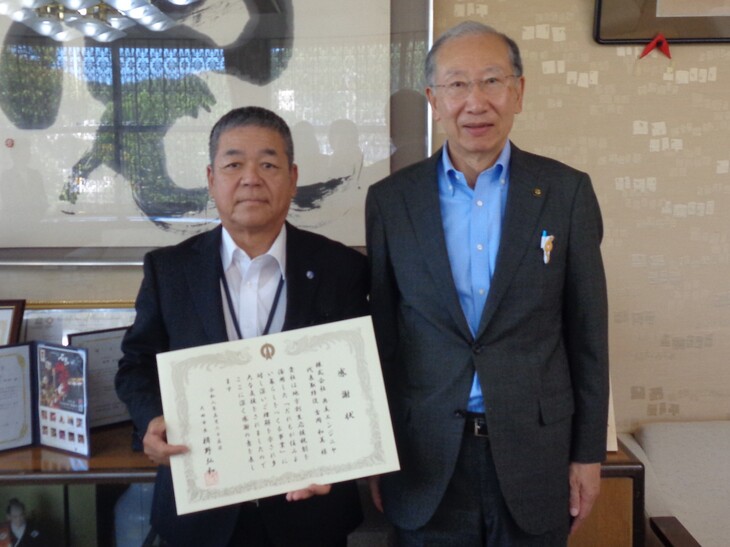 市長と記念撮影をする吉岡代表取締役