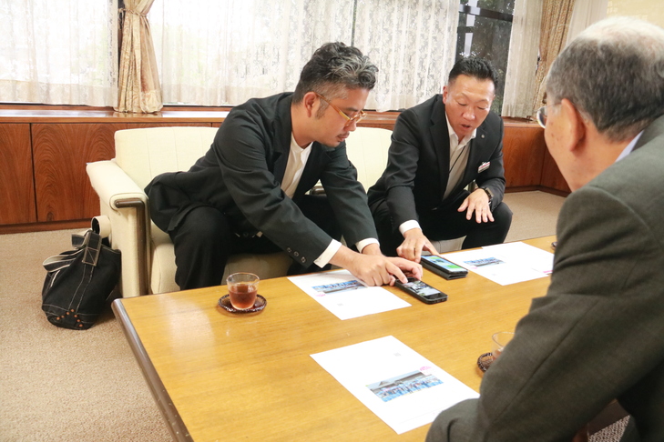 実際に使われている写真を紹介する田中支店長と松葉代表取締役