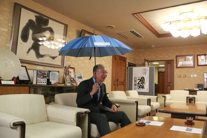 傘をさして感想を話す市長