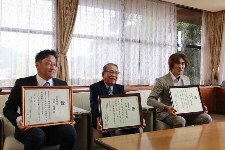 賞状を持つ受賞者の3人